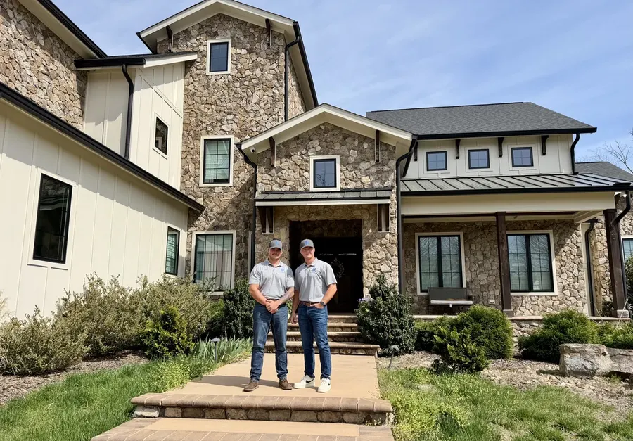 Caleb and Matt — Roof Bros TX founders standing in front of a completed job